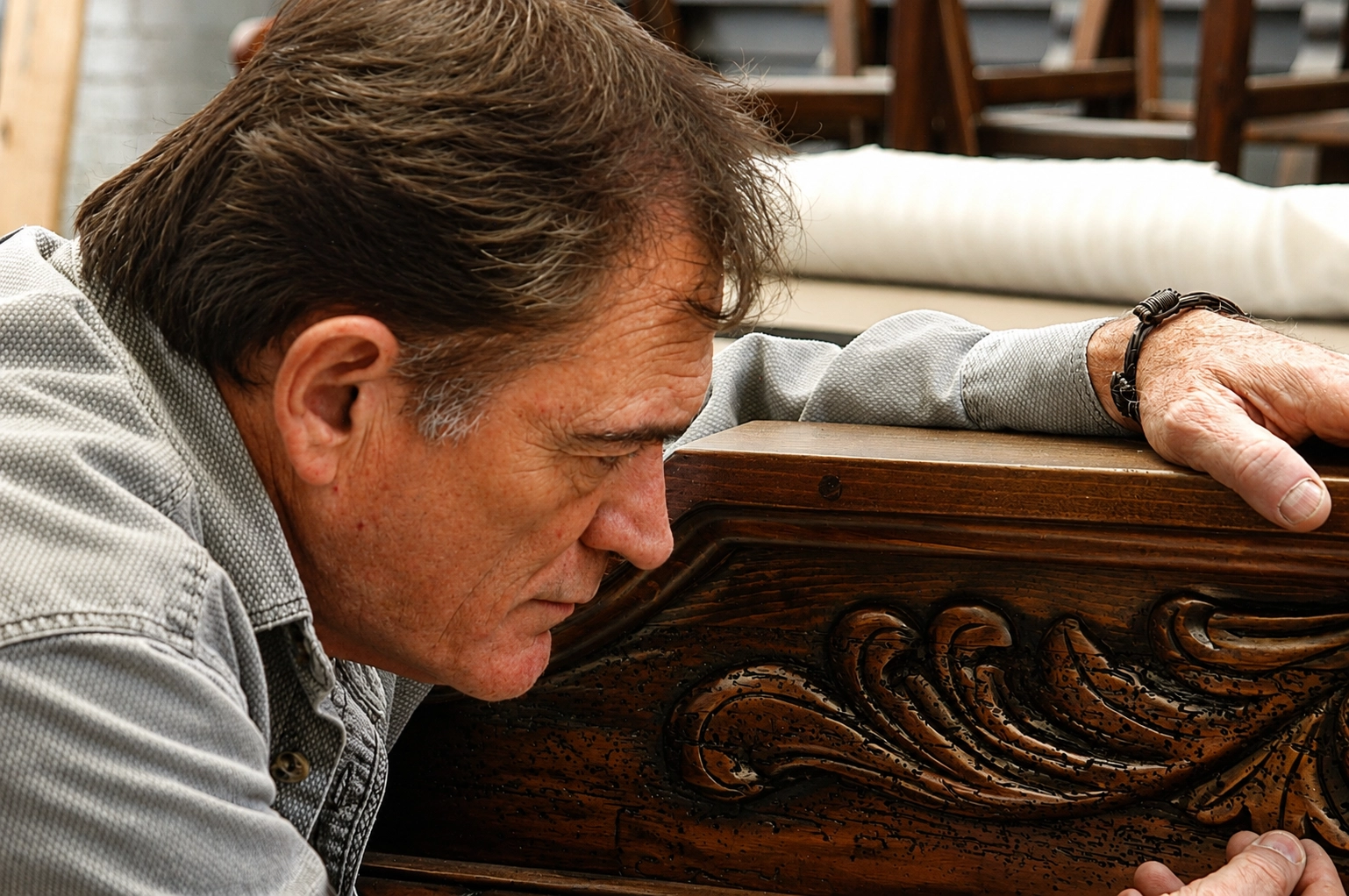 Jorge Kurczyn inspecting carved furniture details